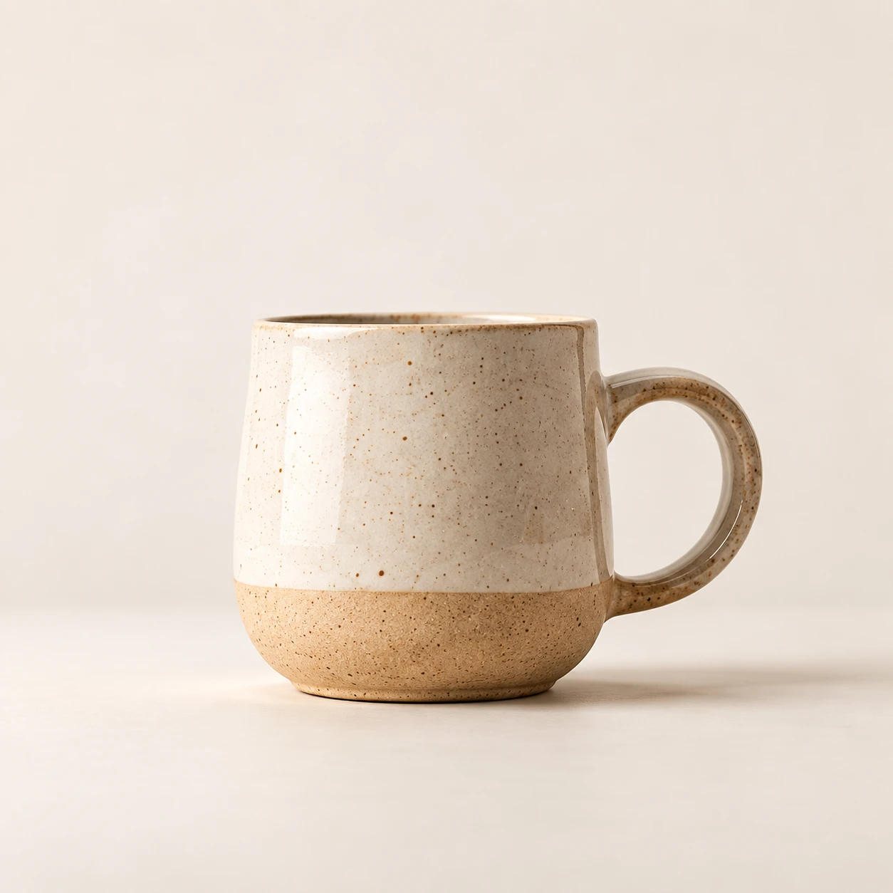 Speckled ceramic mug photographed on a clean neutral background.
